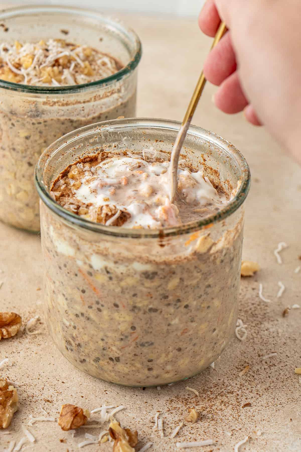 A hand taking a spoonful of the overnight oats.