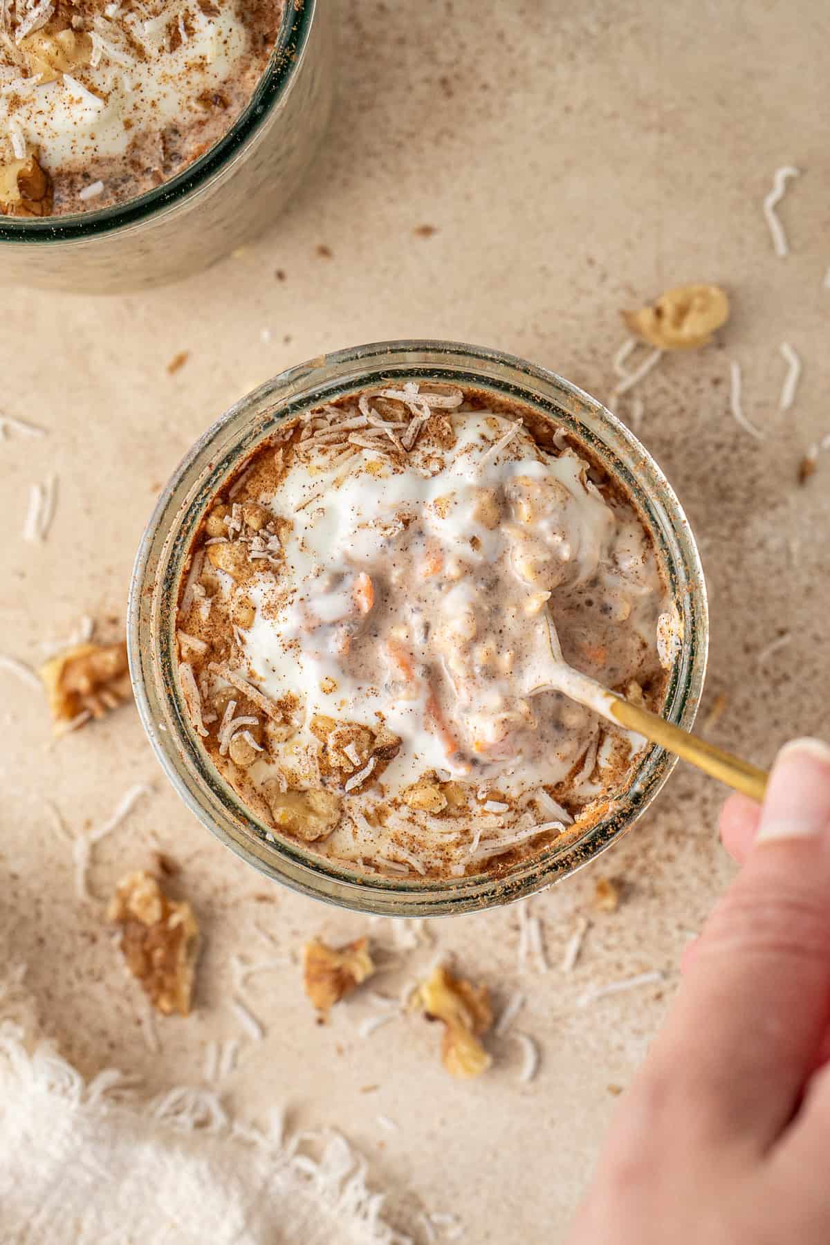 The top of the jar of carrot cake overnight oats with Greek yoghurt and shredded coconut topping.
