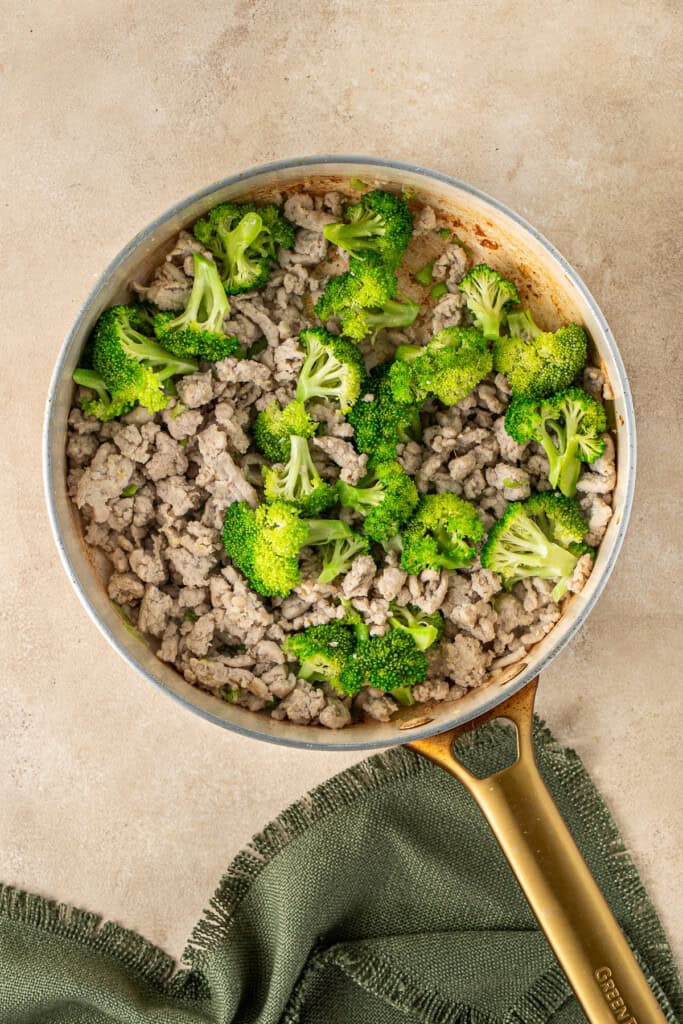 Cooking the broccoli with the chicken mince.