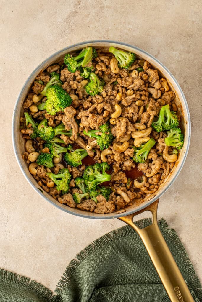 Adding the sauce to the chicken and broccoli.