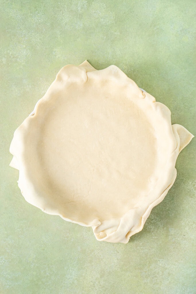 Rolling over the pastry onto the pie dish.