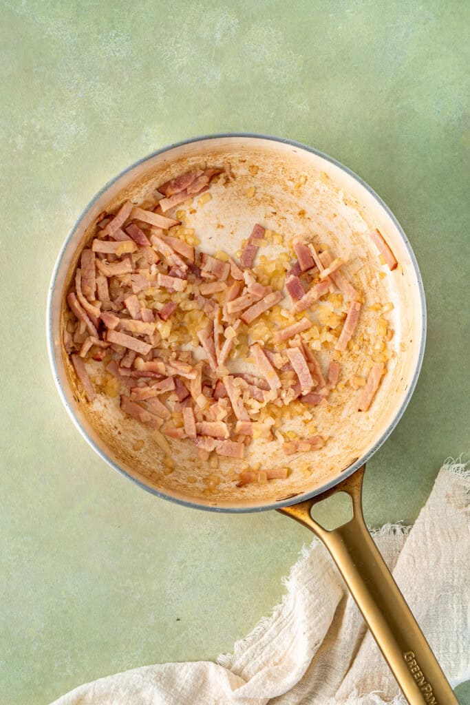 Cooking the bacon and onion in a pan.