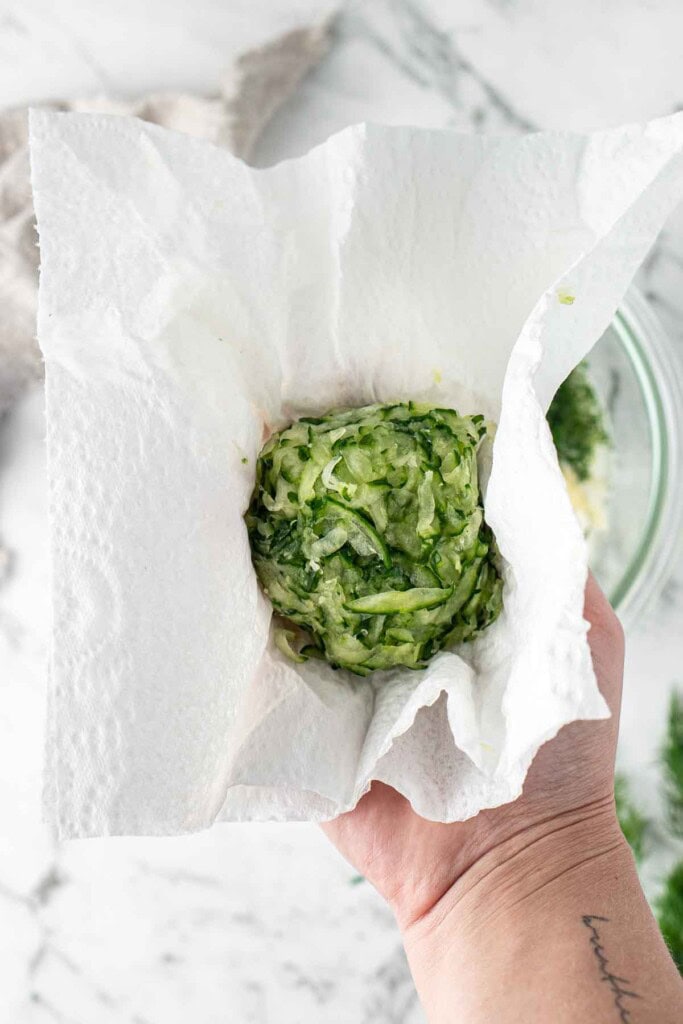 Squeezing out the excess moisture from the cucumber.