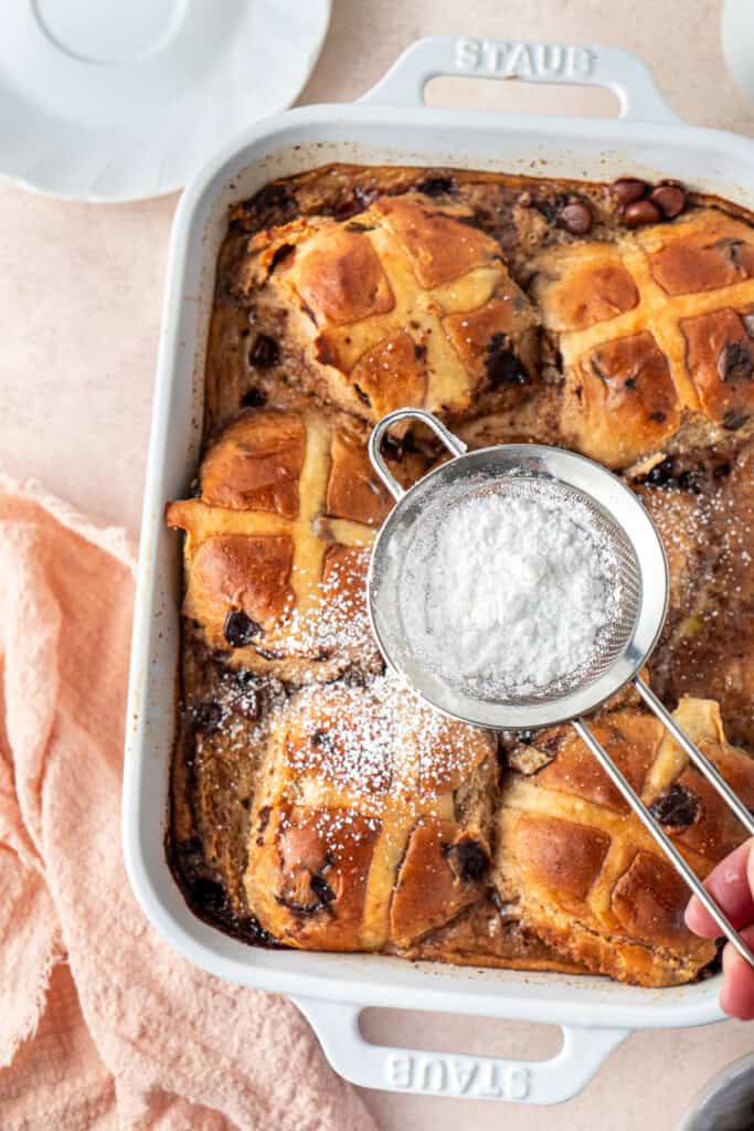 Dusting the pudding with icing sugar.