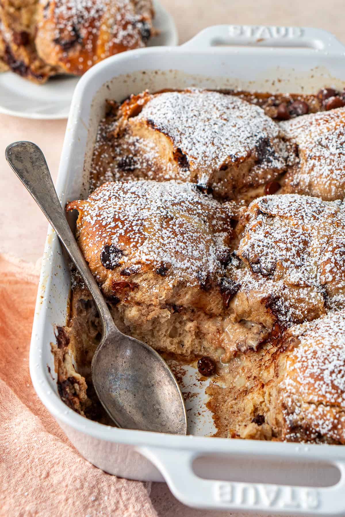 A spoon in the break and butter pudding having been served.