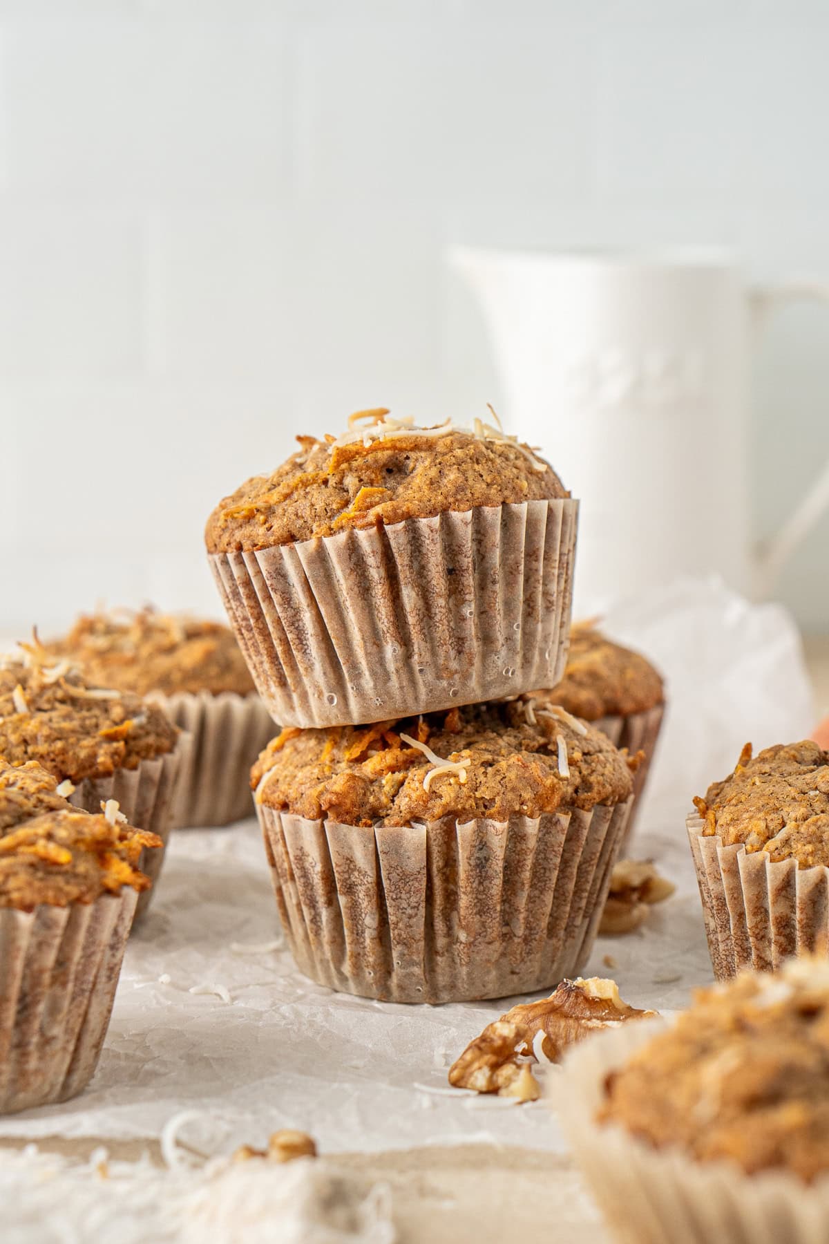 Two vegan carrot cake muffins stacked on top of each other.