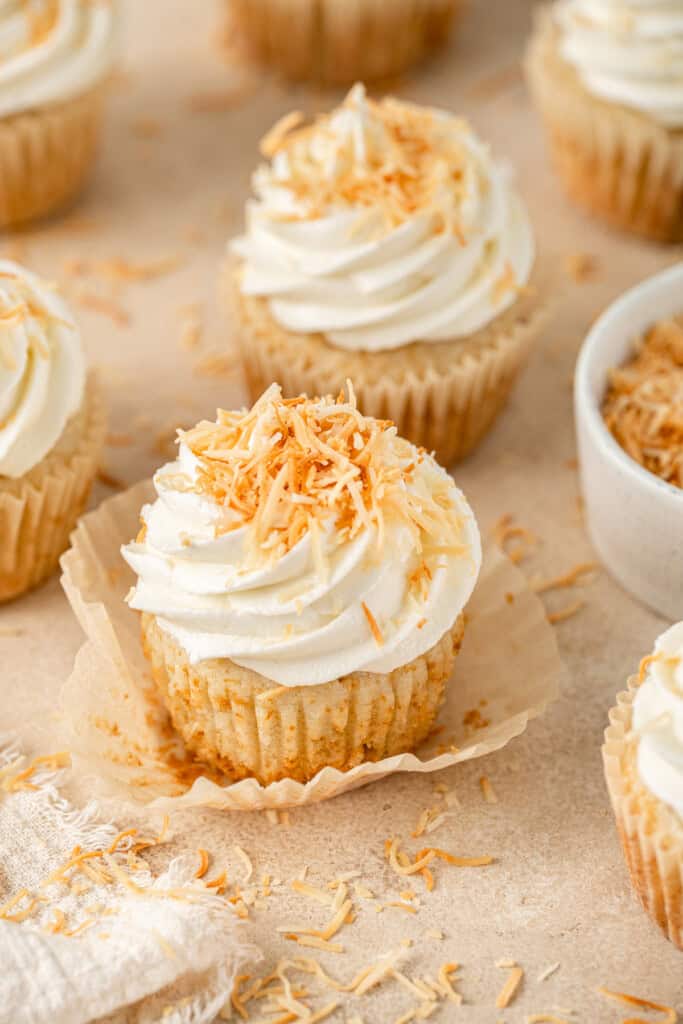Vegan coconut cupcakes topped with toasted coconut.