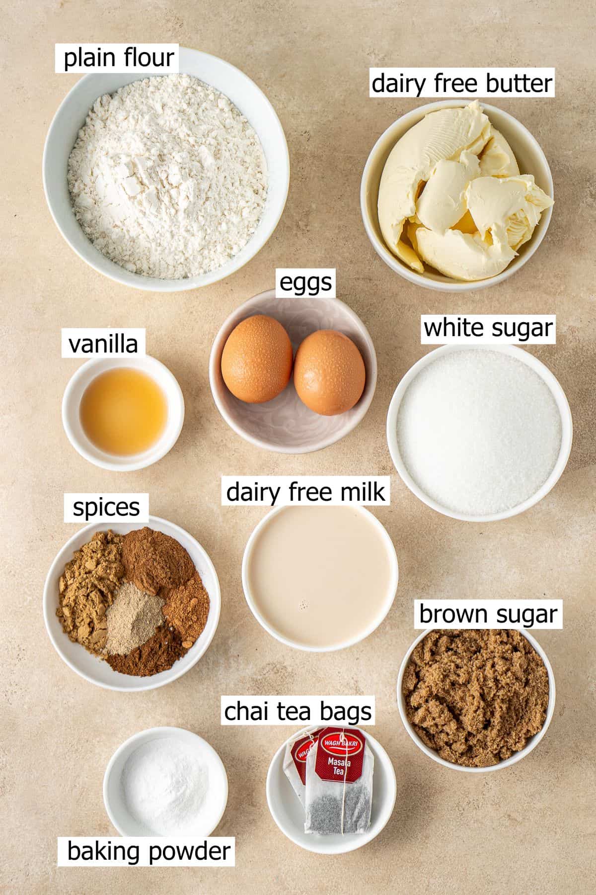 All ingredients needed to make chai tea cake laid out in bowls.