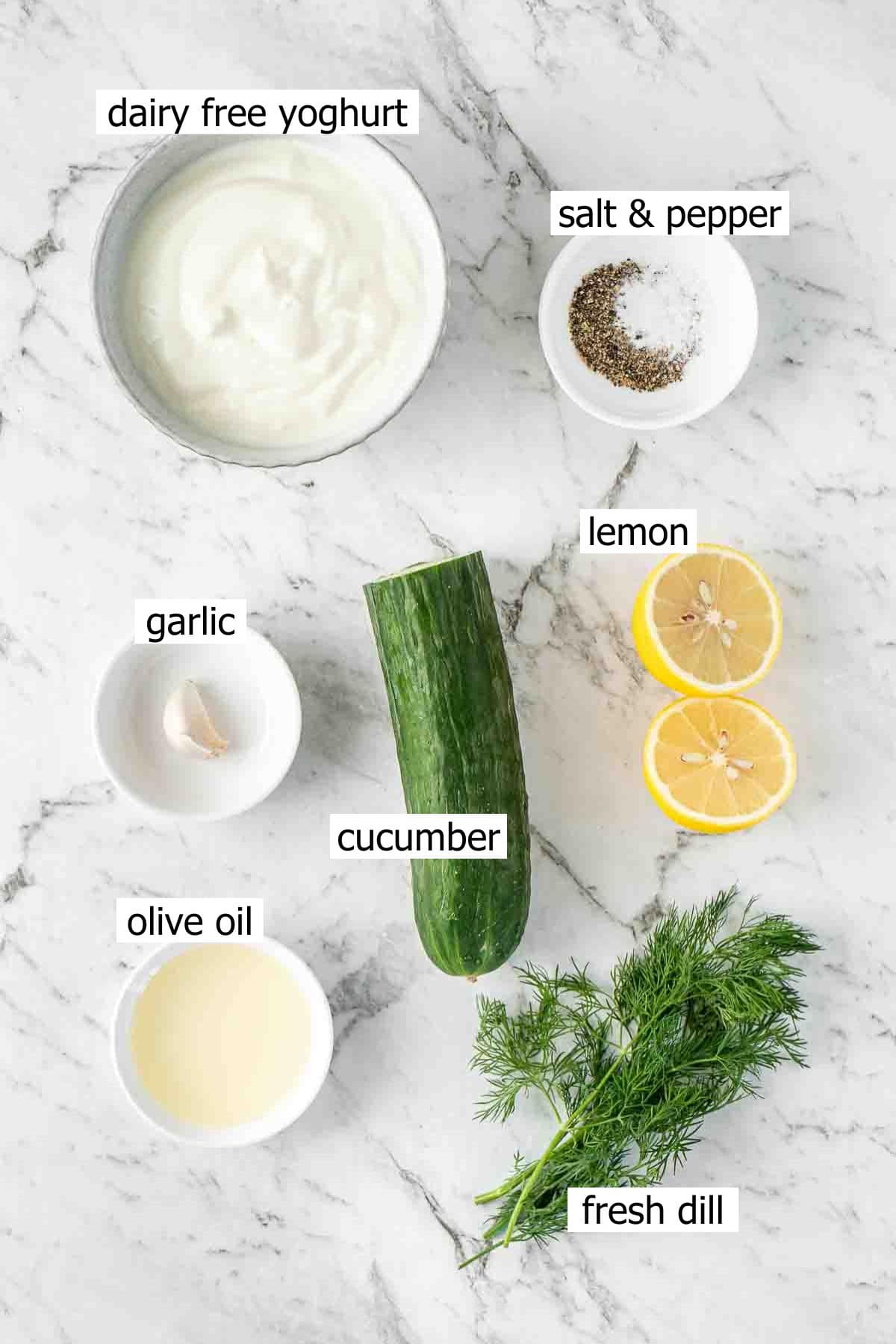 All ingredients needed to make dairy free tzatziki laid out in small bowls.
