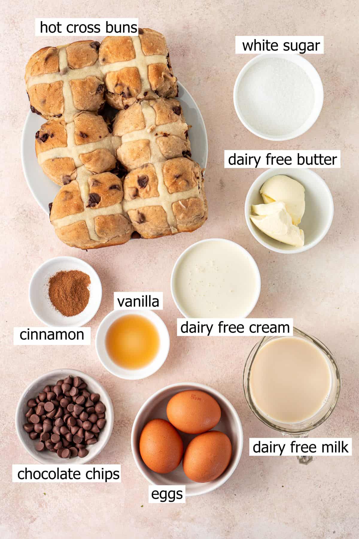 All ingredients needed to make hot cross bun bread and butter pudding laid out in small bowls.