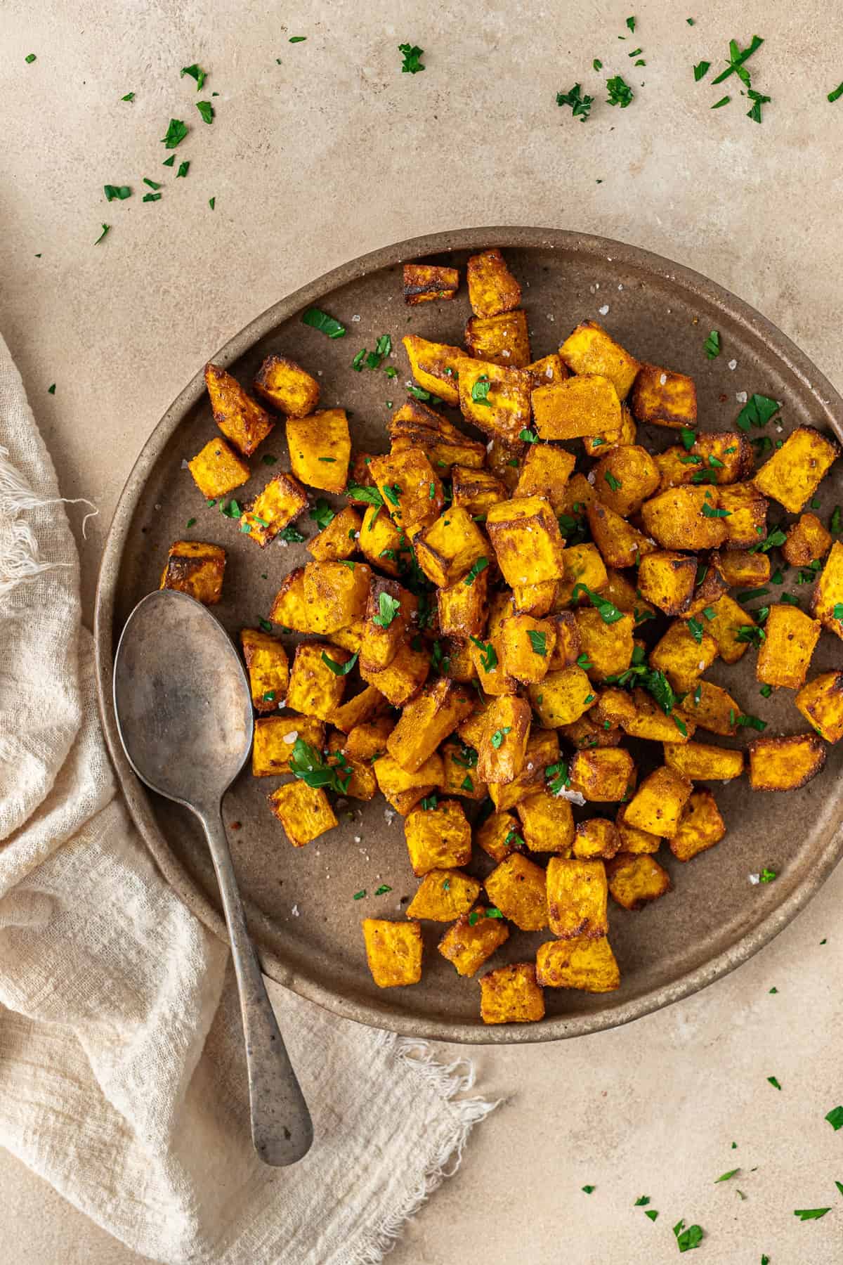The air fryer pumpkin served on a plate with a spoon.
