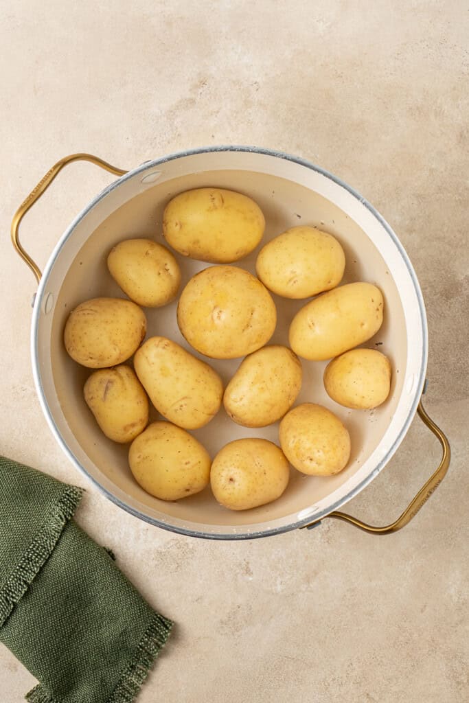 Boiling the potatoes in a large pot.
