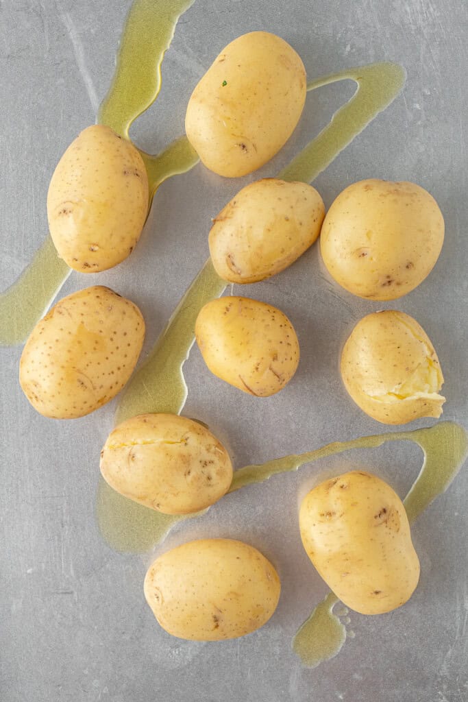 The cooked potatoes on a tray with oil.