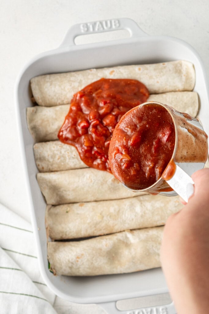 Pouring over the enchilada sauce before going into the oven.