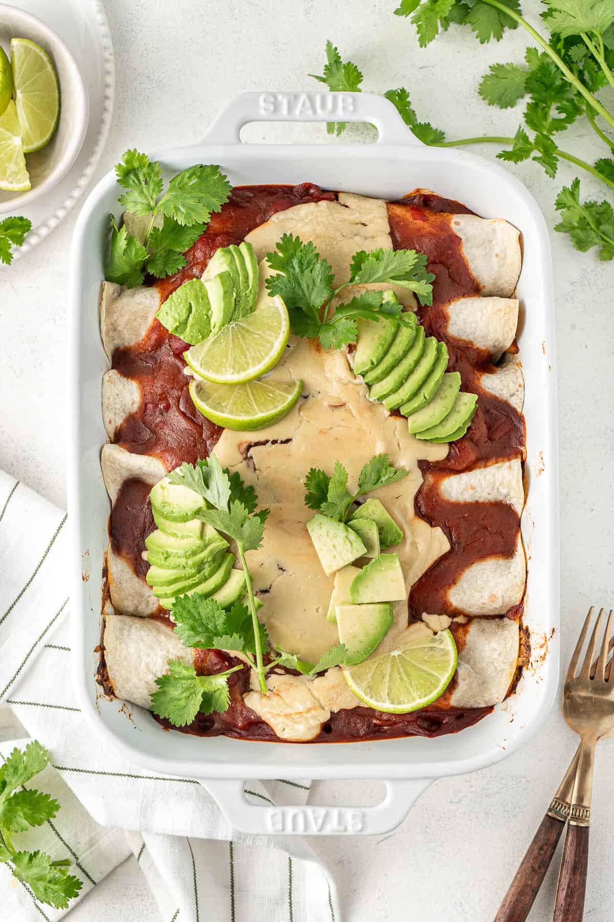 The dairy free enchiladas with toppings of lime, avocado and coriander. 