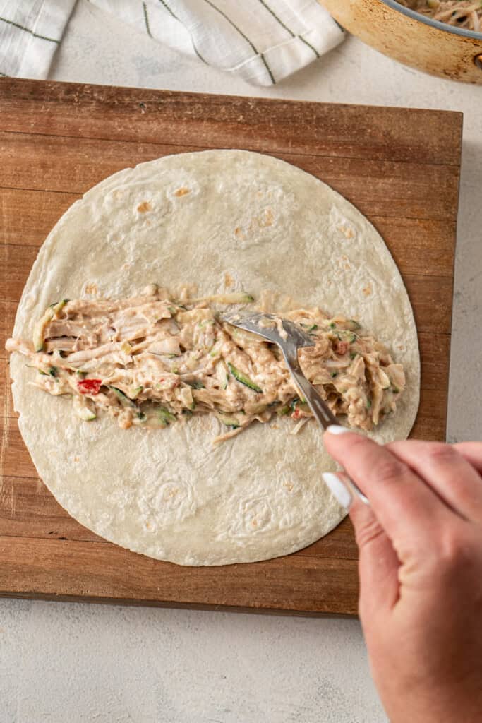 Placing the filling into the flour tortilla.