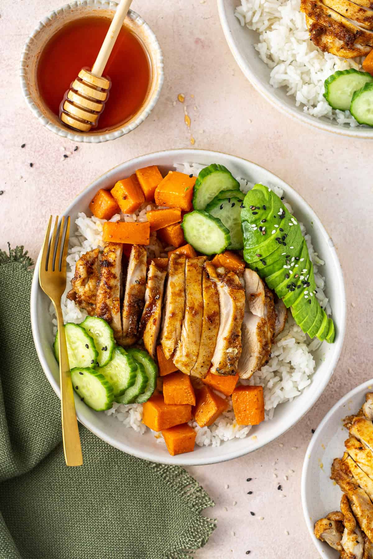 Hot honey chicken bowls with a fork and extra hot honey.