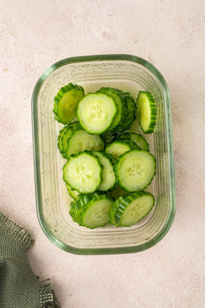 The pickled cucumber in a container.