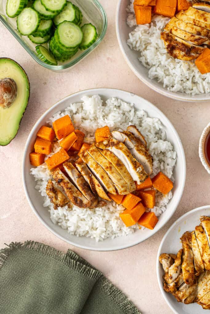 Layering the chicken onto the rice bowl.