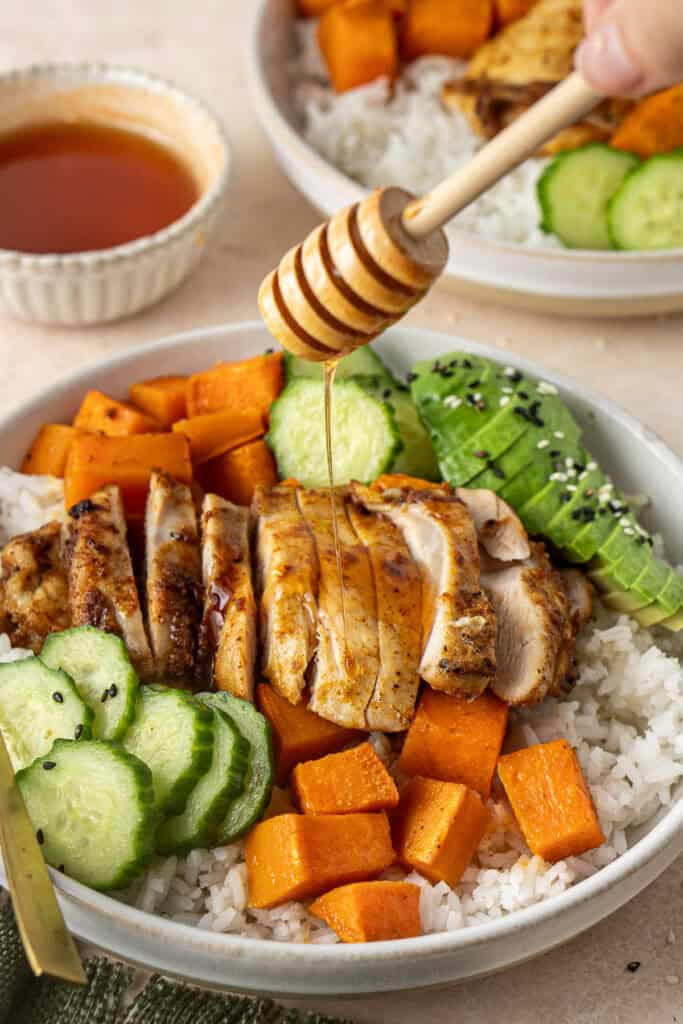 Drizzling hot honey over the chicken and sweet potato bowl.