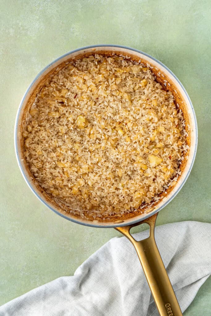 The onion and rice cooking in the pan.