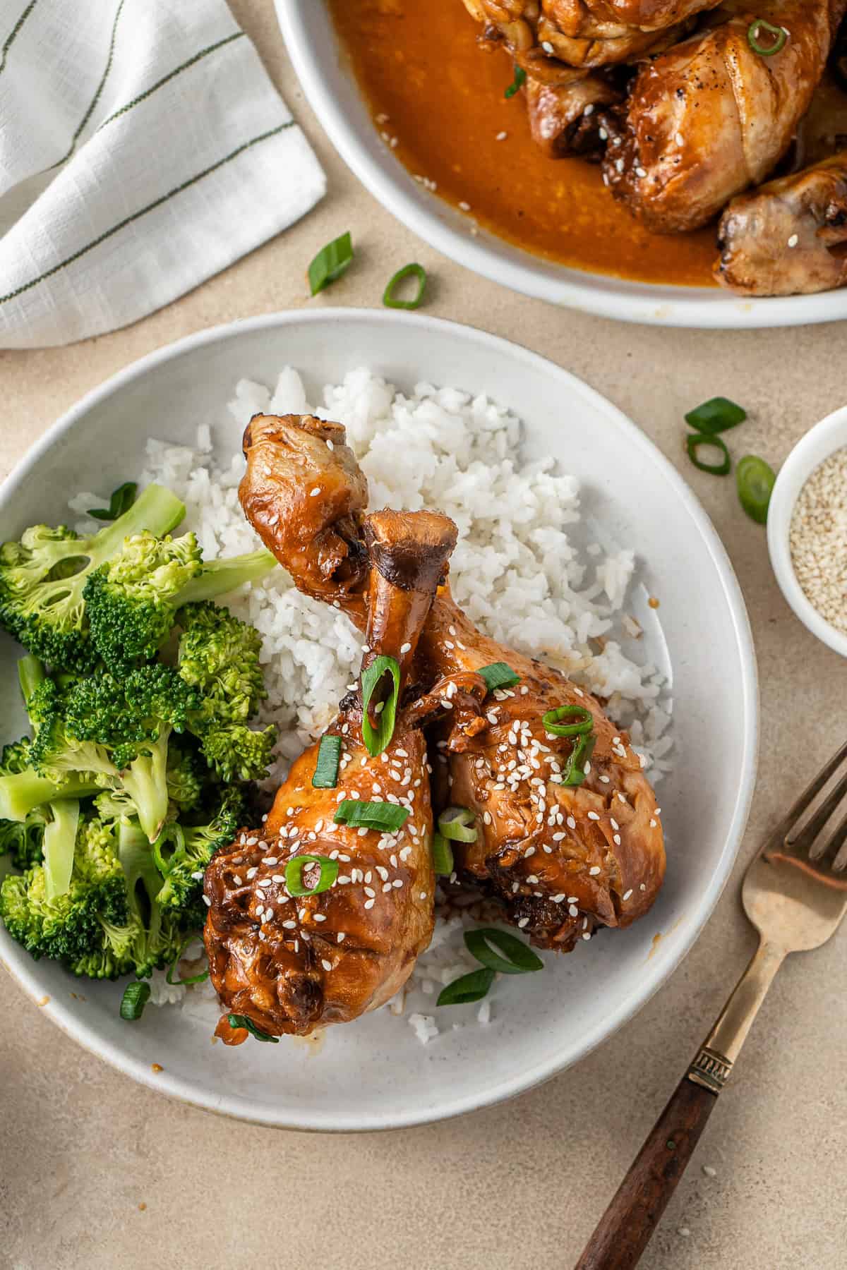Honey garlic chicken drumsticks on rice with broccoli.