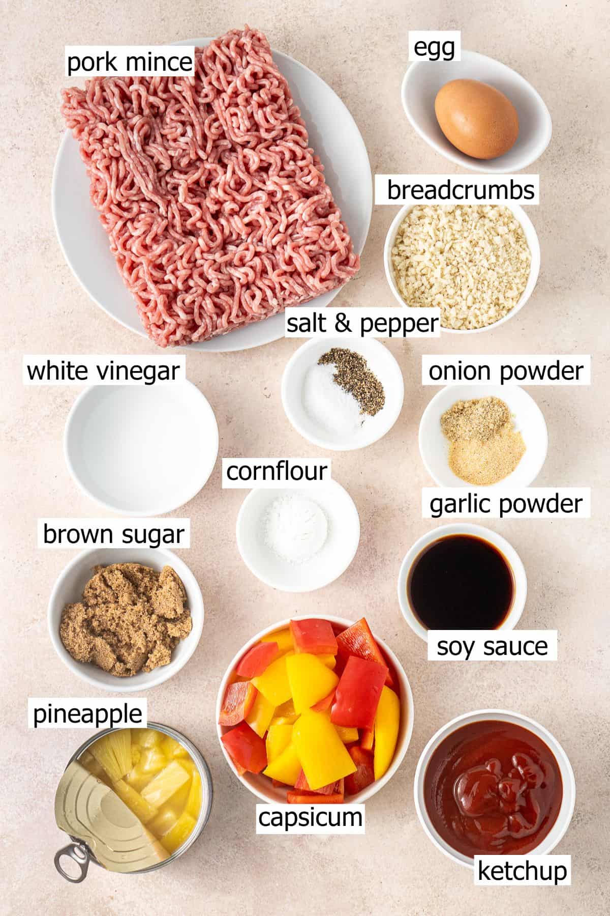 All ingredients needed to make sweet and sour pork meatballs laid out in bowls.