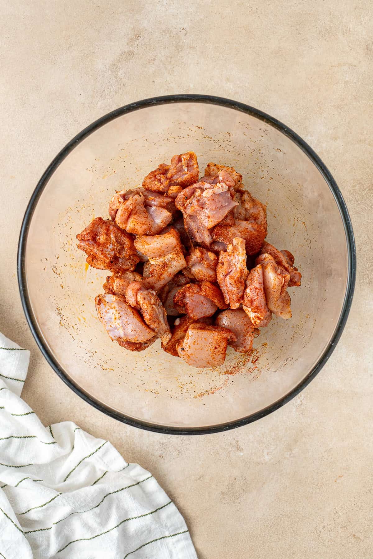 Tossing the chicken thigh pieces with the spices.