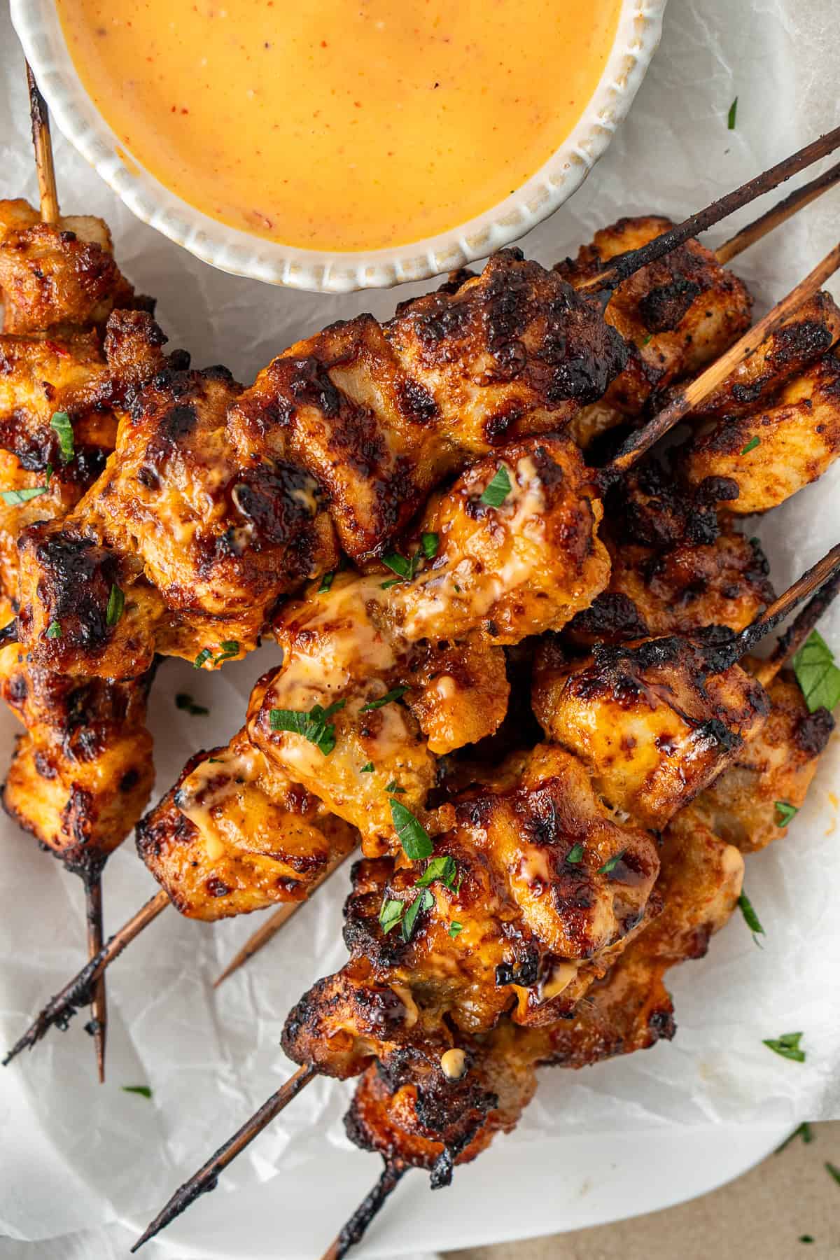 Close up of bang bang chicken skewers served on a plate. 