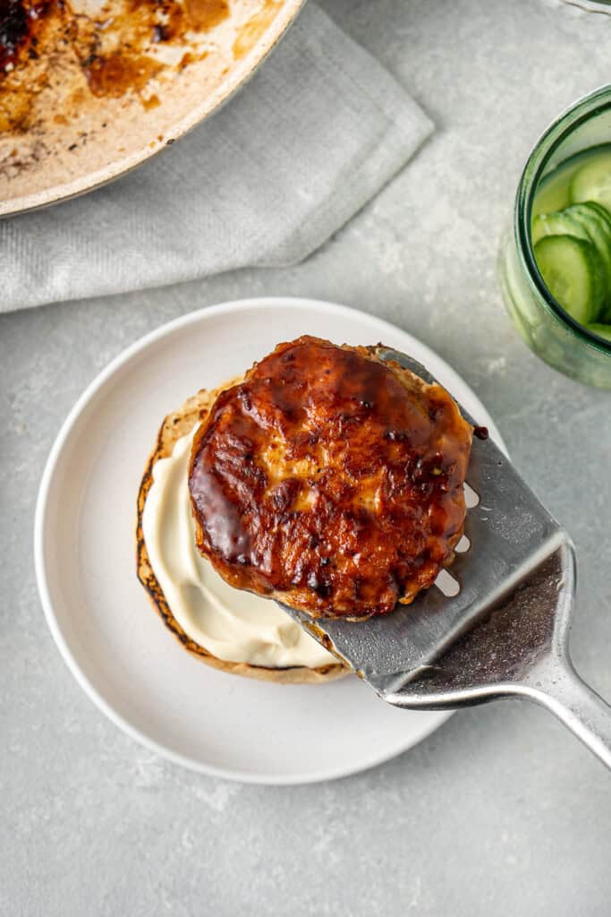 Adding the chicken burger onto the bun.