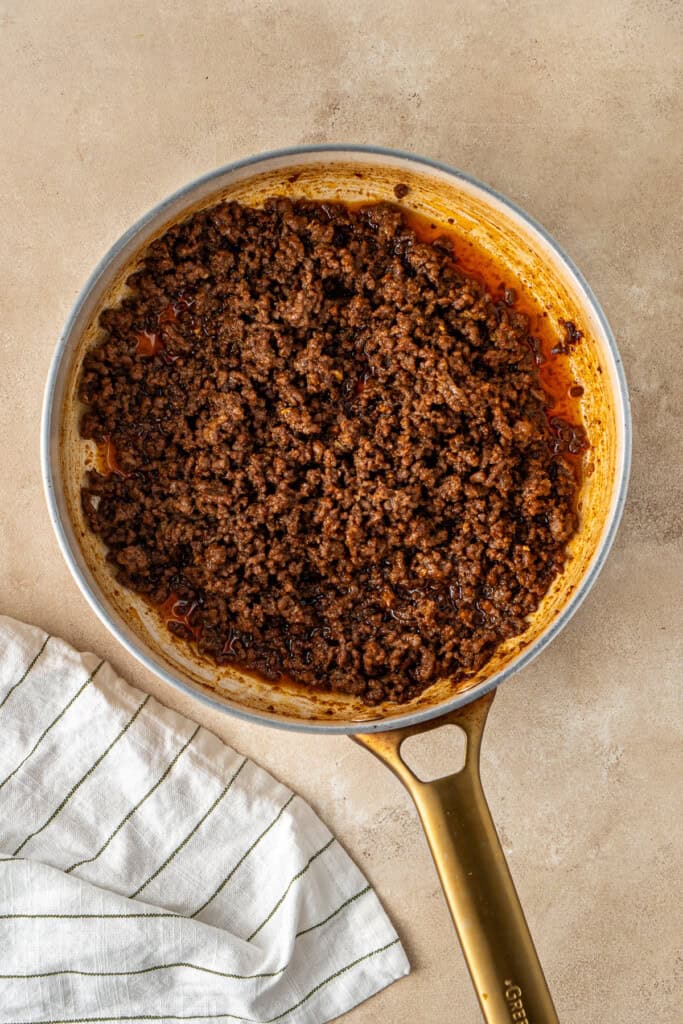 The beef mince in the sauce in a frying pan.