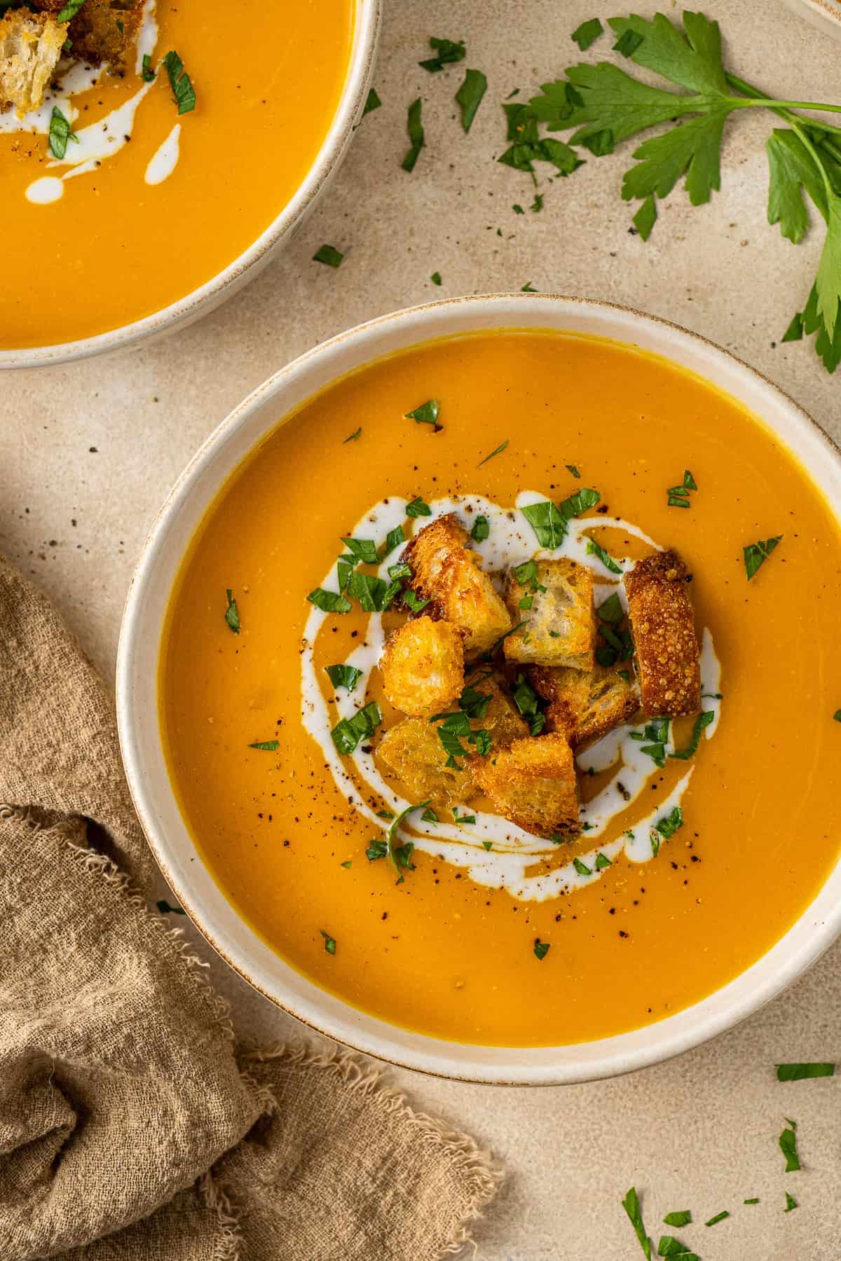 Close up of the sweet potato soup topped with croutons and parsley.