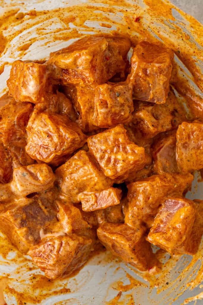 Close up of the marinated salmon cubes in a bowl.