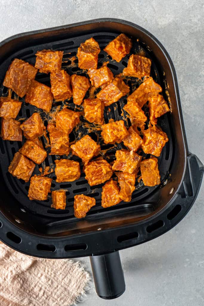 Marinated bang bang salmon in the air fryer basket.