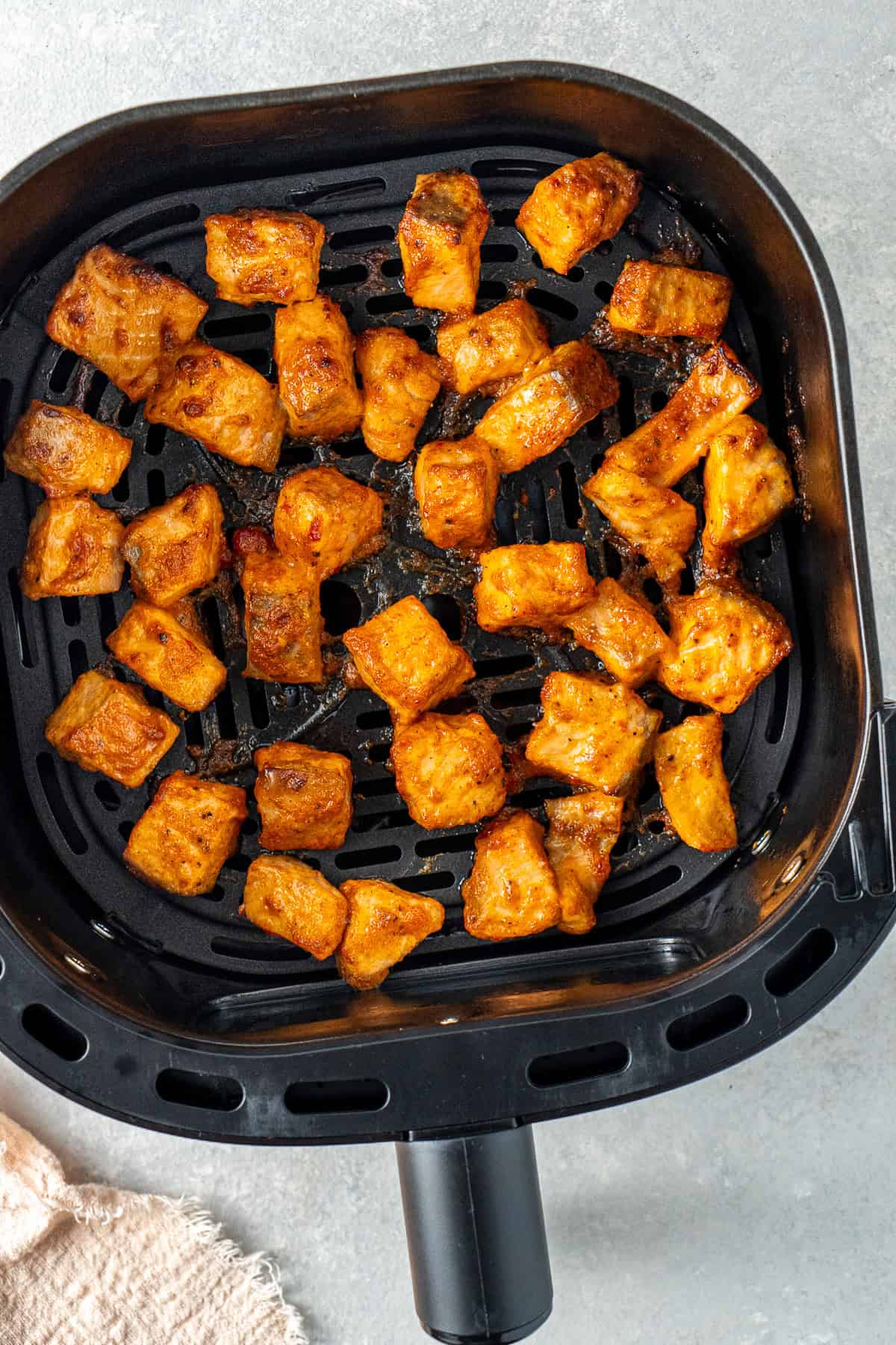 The cooked bang bang salmon in the air fryer basket.