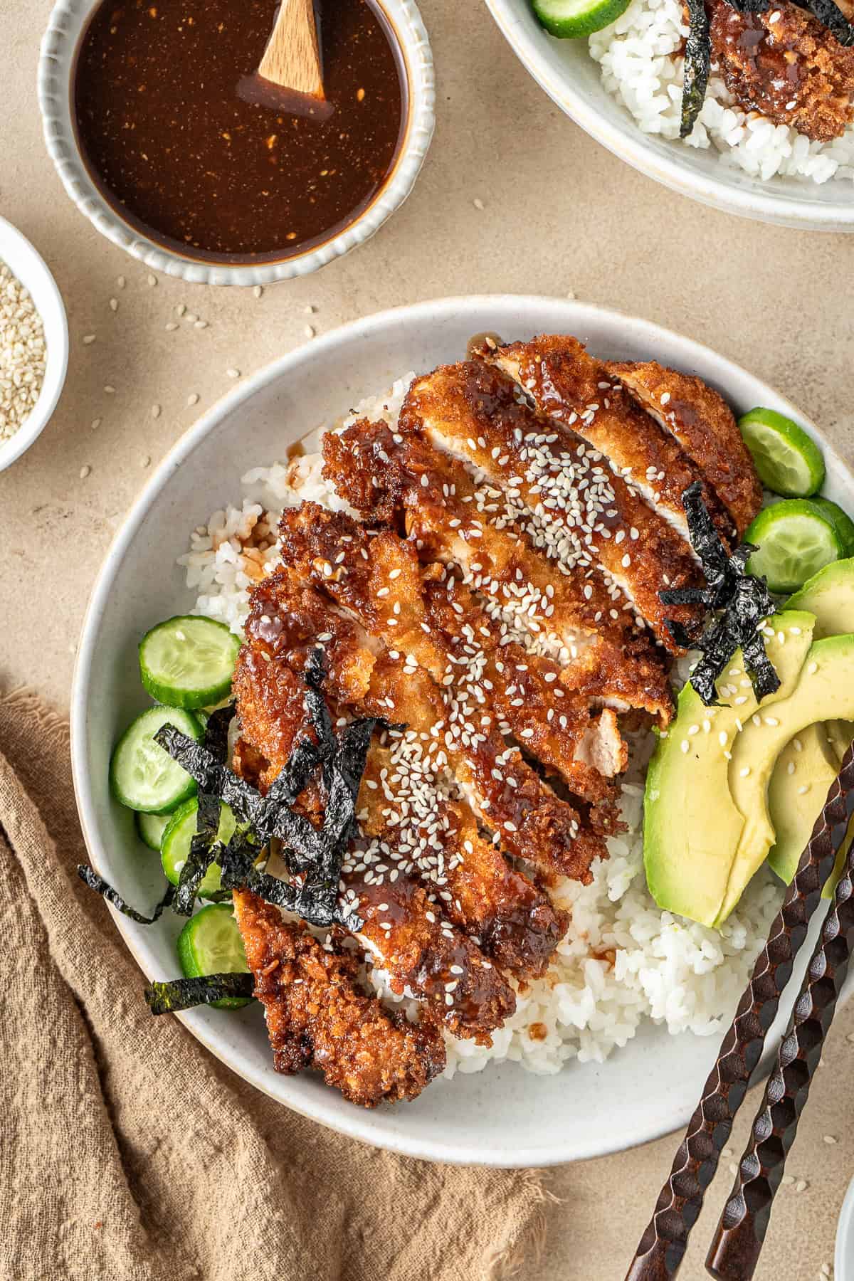 Close up of chicken katsu in a rice bowl.