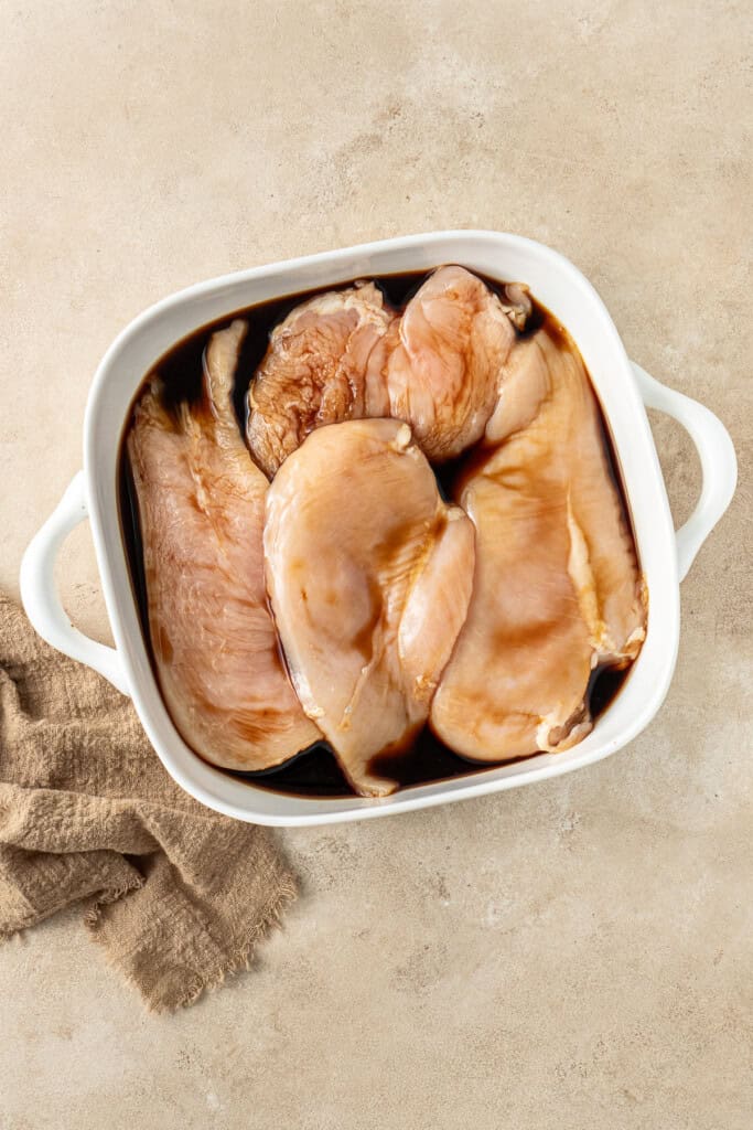 Marinating the chicken in soy sauce.