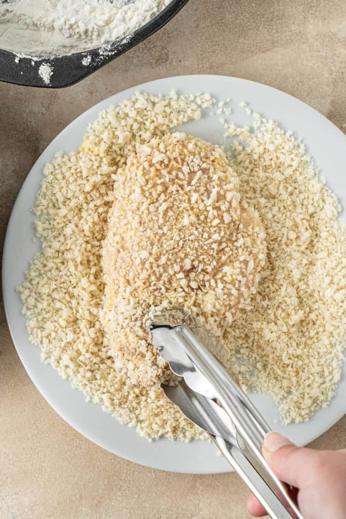 Coating the chicken in panko crumbs.