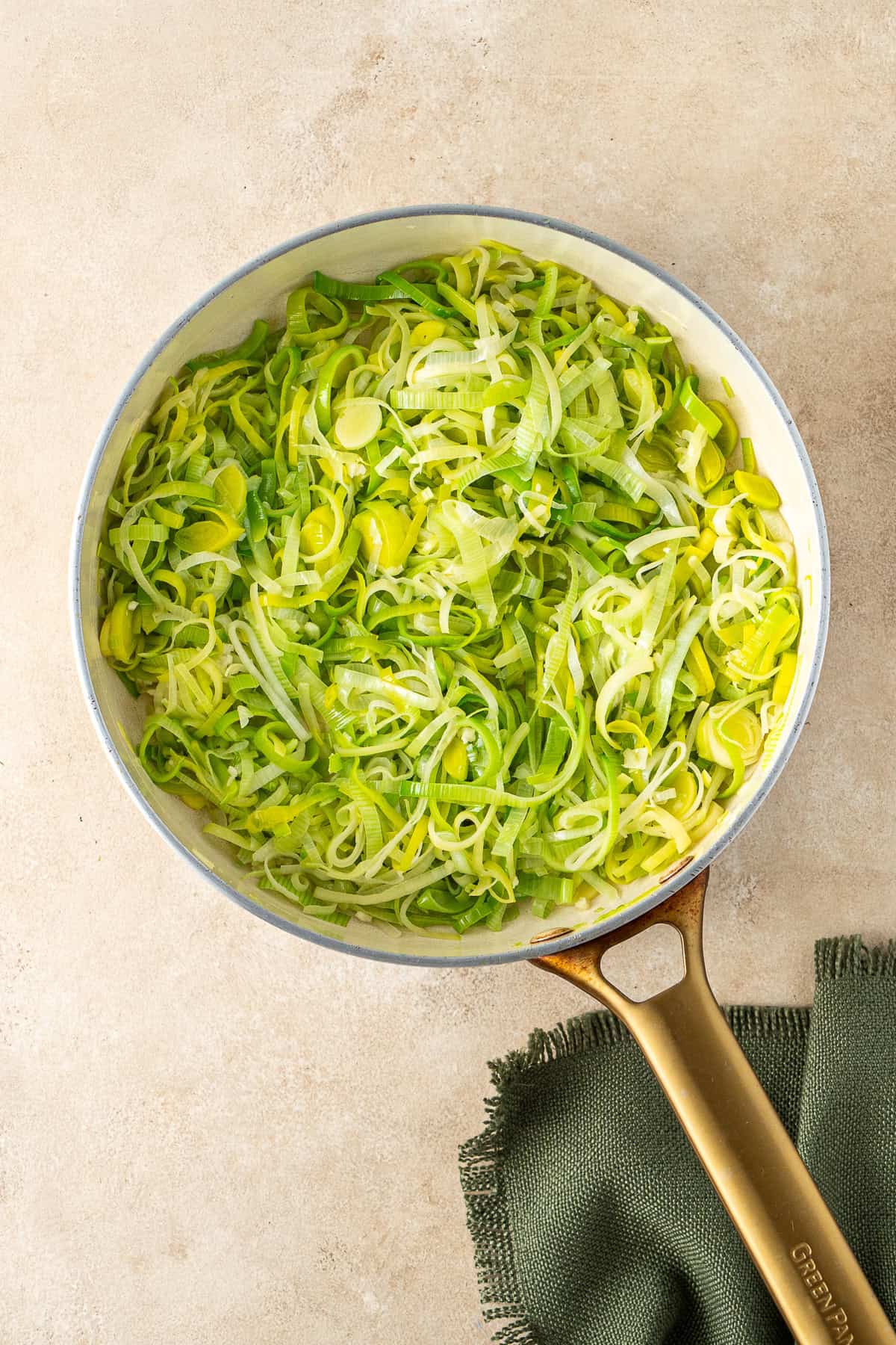The softened leeks in a frying pan.