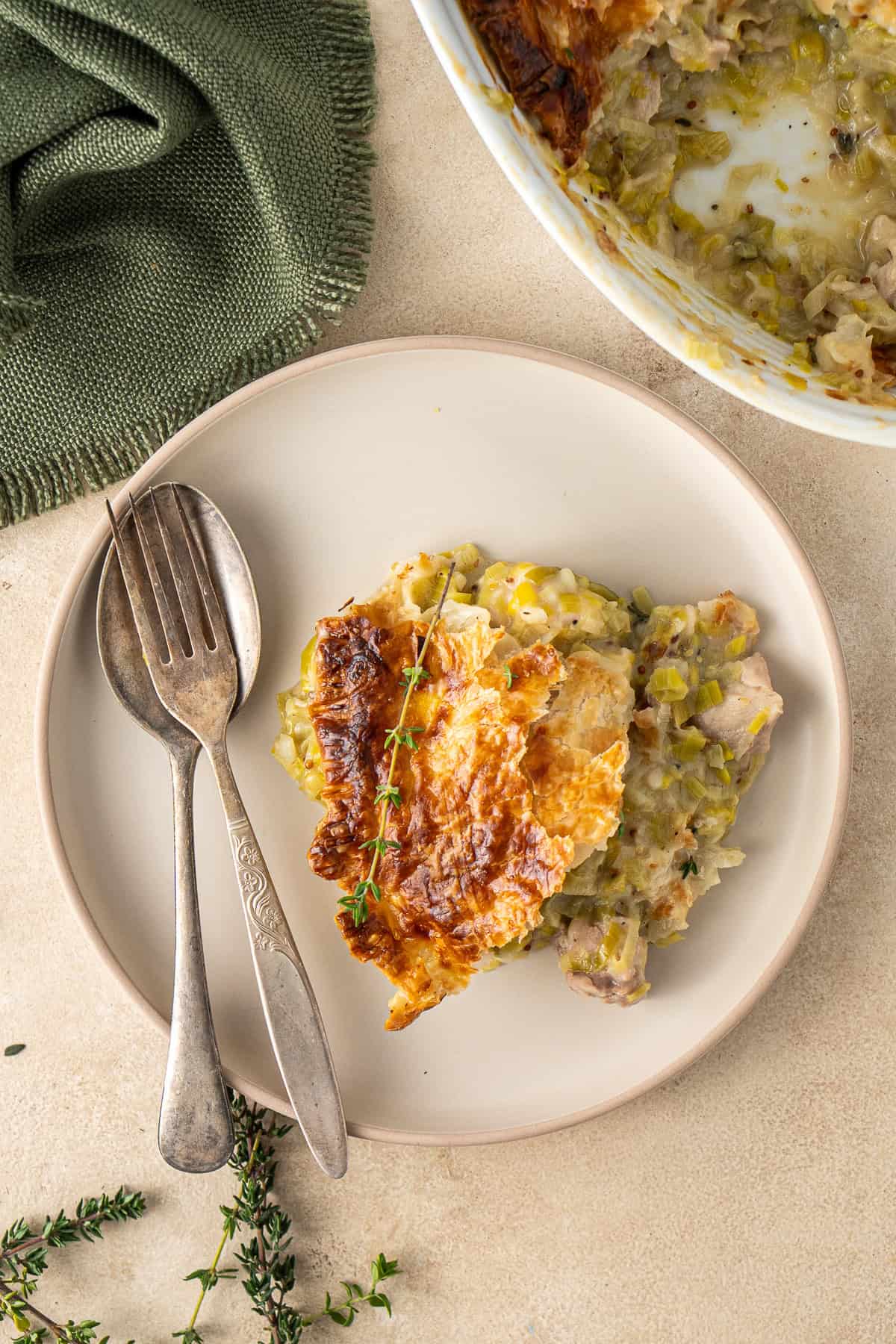 A piece of the chicken and leek pie served onto a plate with cutlery.