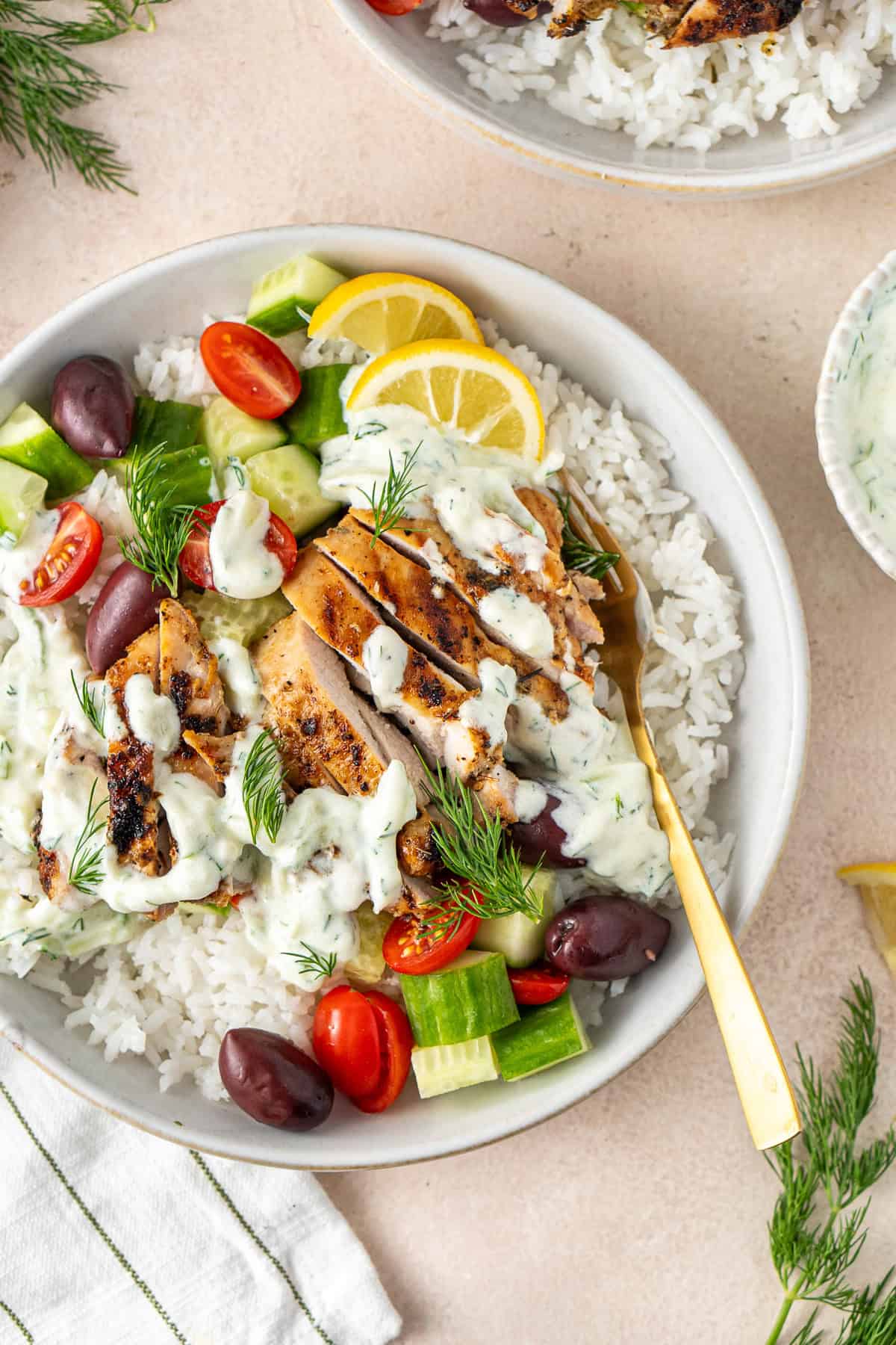 Close up of Greek chicken rice bowls with a fork.