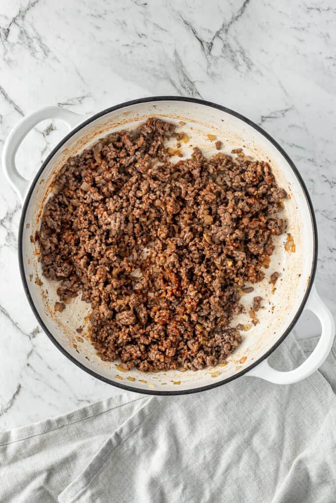 Cooking the beef with the tomato paste and spices.