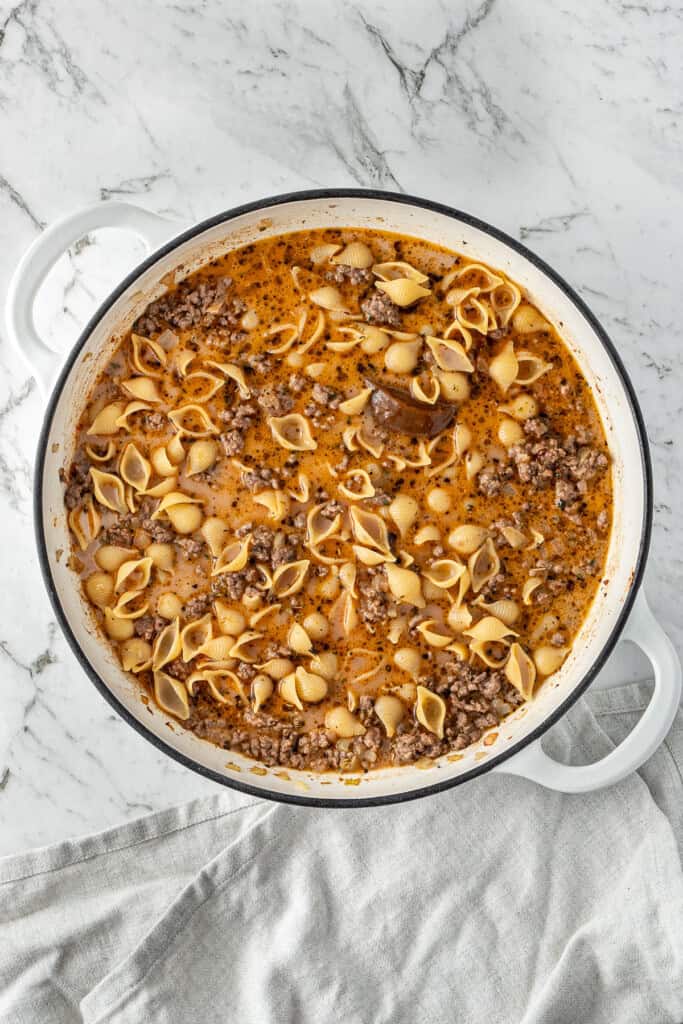 Adding the liquid and pasta to the pot ready to cook.