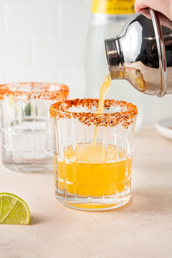 Pouring the mocktail into the prepared class.