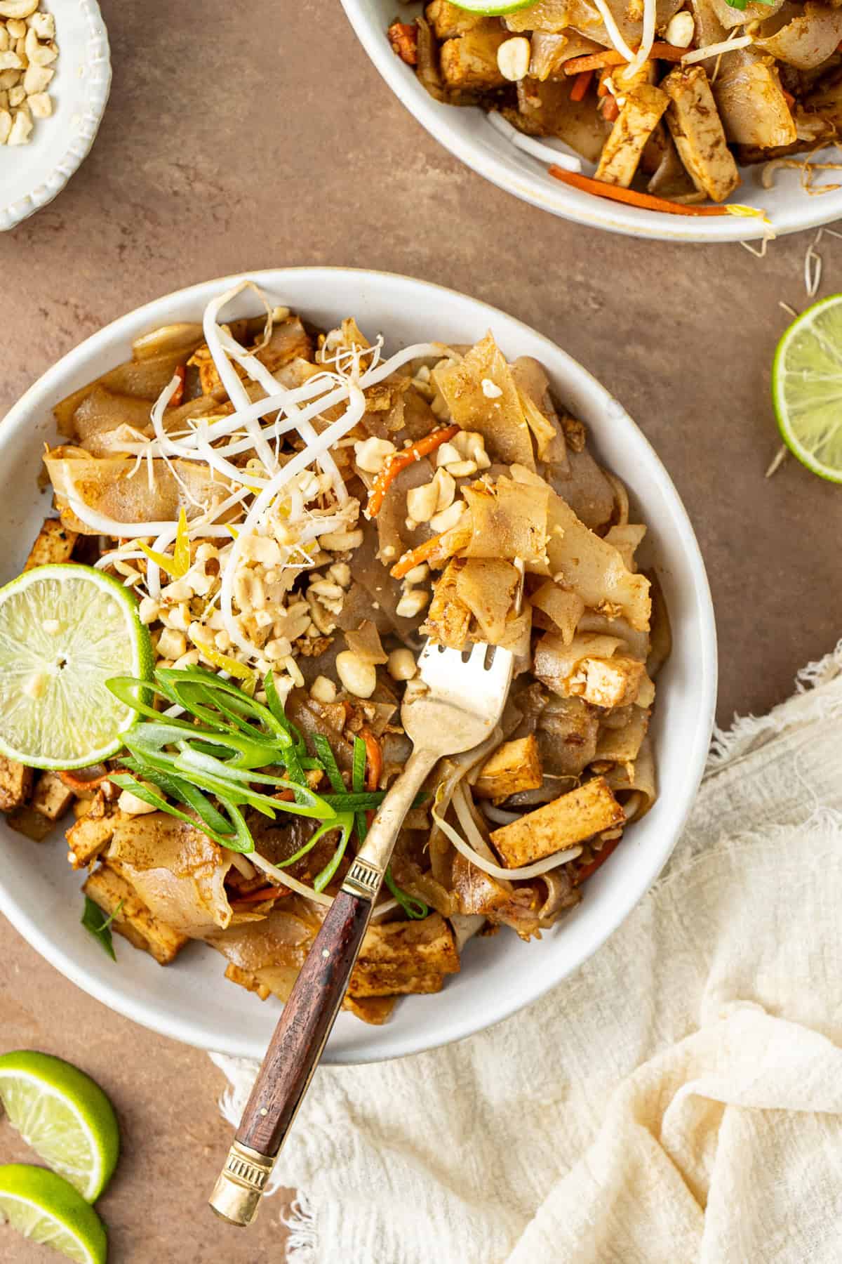 A fork in a bowl of tofu Pad Thai.