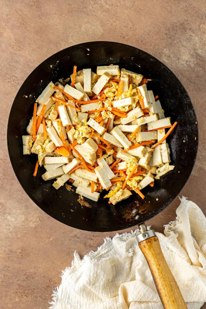 The cut tofu added to the wok with the eggs and carrot.
