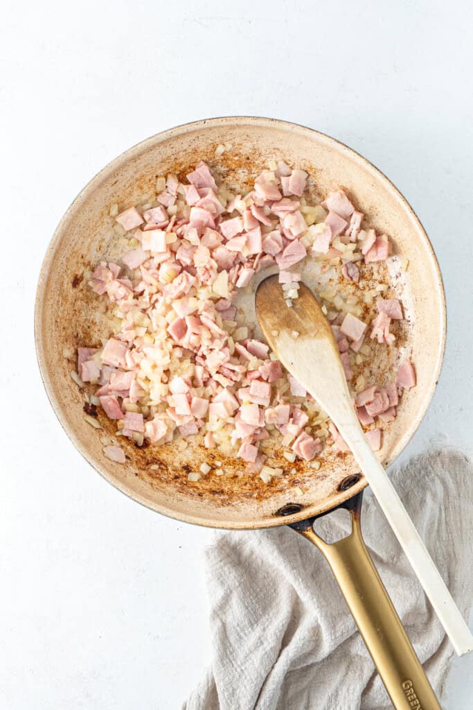 Cooking the onions and bacon in a frying pan.