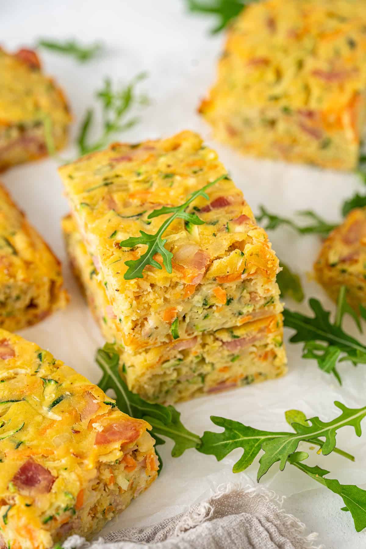 Two slices of zucchini slice with bacon stacked together.