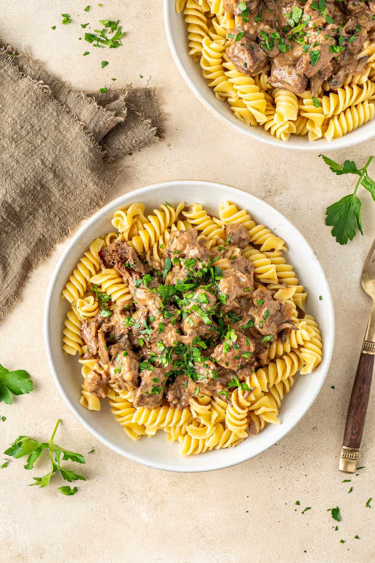 Dairy Free beef stroganoff plated up with pasta and fresh parsley.