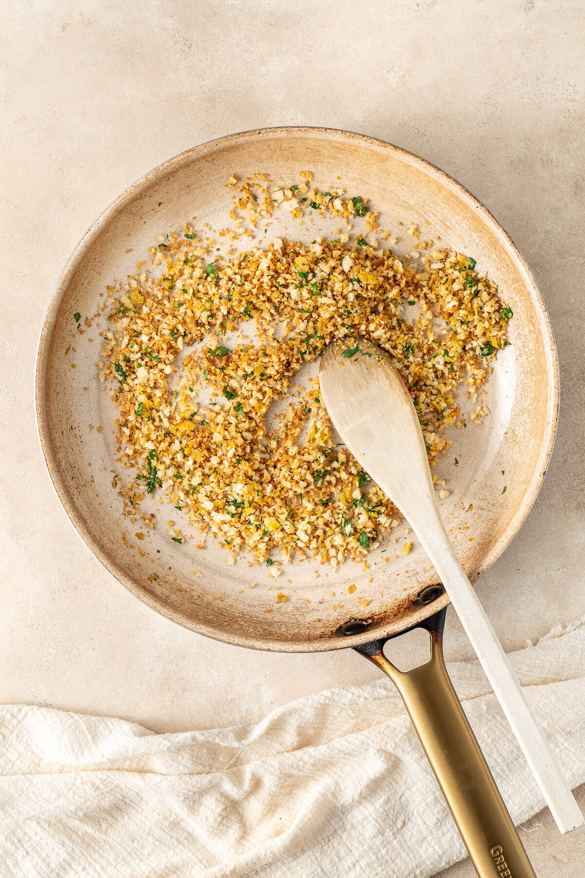 Toasting the breadcrumbs in a frying pan.